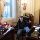 Richard Barnett, a supporter of U.S. President Donald Trump sits inside the office of US Speaker of the House Nancy Pelosi after breaking into the Capitol building with other violent insurgents on January 6, 2021.